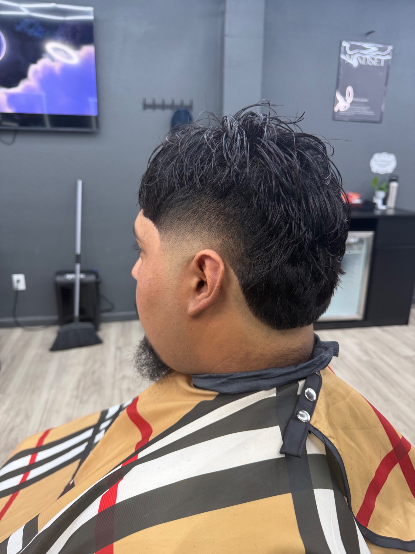 Curly mullet with mid fade and lined beard